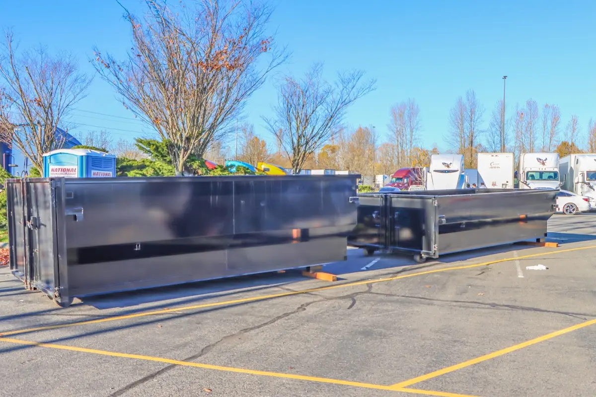 Professional dumpster rental service with roll-off container on residential driveway in Plover